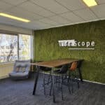 Plantenwand op kantoor: Kunst moswand als achtergrond voor logo.